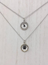 Load image into Gallery viewer, Close up picture of two sterling silver necklaces. The top necklace has a black cat pendant while the second necklace has a black paw print pendant
