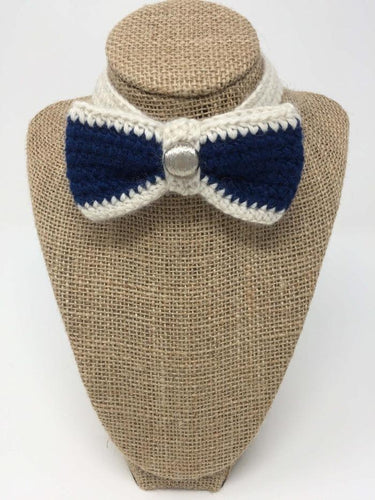 Blue and ivory hand-knitted pet bow tie on the neck of a tan brown bust