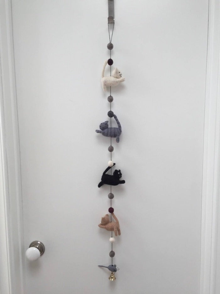 Picture of a felt cat door garland featuring four cats and a mouse hanging from a white door