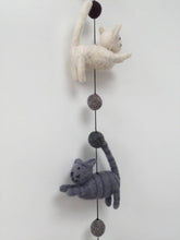 Load image into Gallery viewer, Picture of a white felt cat and a grey felt cat on a string and grey balls between them
