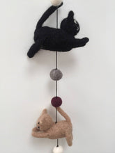 Load image into Gallery viewer, Picture of a black felt cat and a brown felt cat on a string with felt balls between them 
