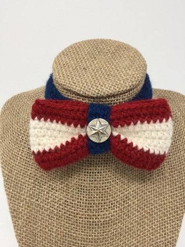 Picture of a red, white, and blue colored hand-knitted pet collar bow tie around a tan brown bust 