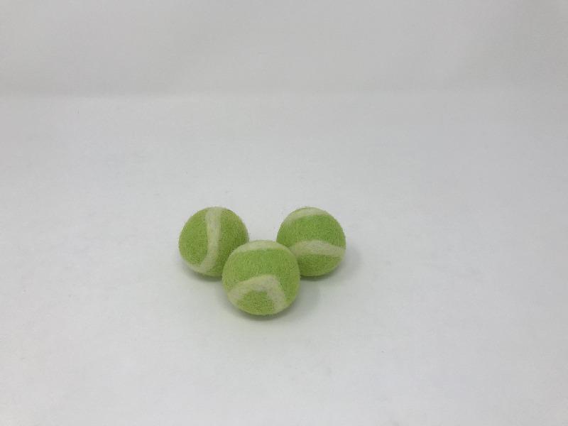 Picture of three green and white tennis balls for pets on a white background