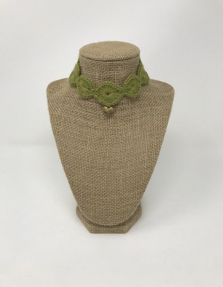Picture of an olive green hand-knitted pet collar with a gold colored charm around a tan brown bust 