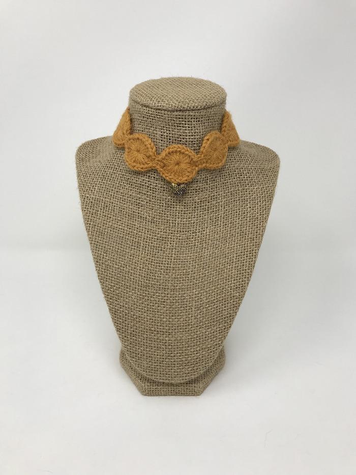 Picture of a ginger colored pet collar with a gold colored charm around a tan brown bust 