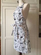 Load image into Gallery viewer, Black and white kitchen apron on a white mannequin showcasing the side of the apron 
