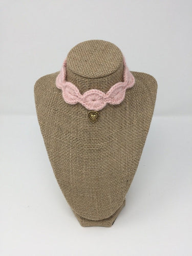 Pink Hand Crochet Alpaca Wool Pet Collars with gold colored pendant around a tan brown bust 