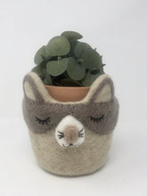 Load image into Gallery viewer, Grey and off-white felt cat plant holder with a plant inside of it standing on an all white surface
